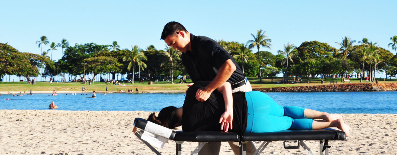 Dr. Shaun giving an adjustment on the beach.