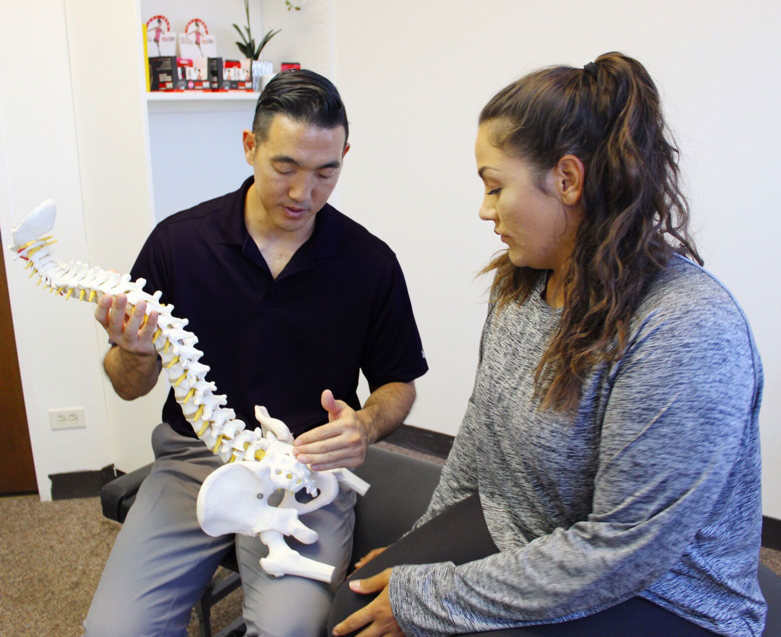 Dr. Shaun Ohira, with spine, speaking to the patient.