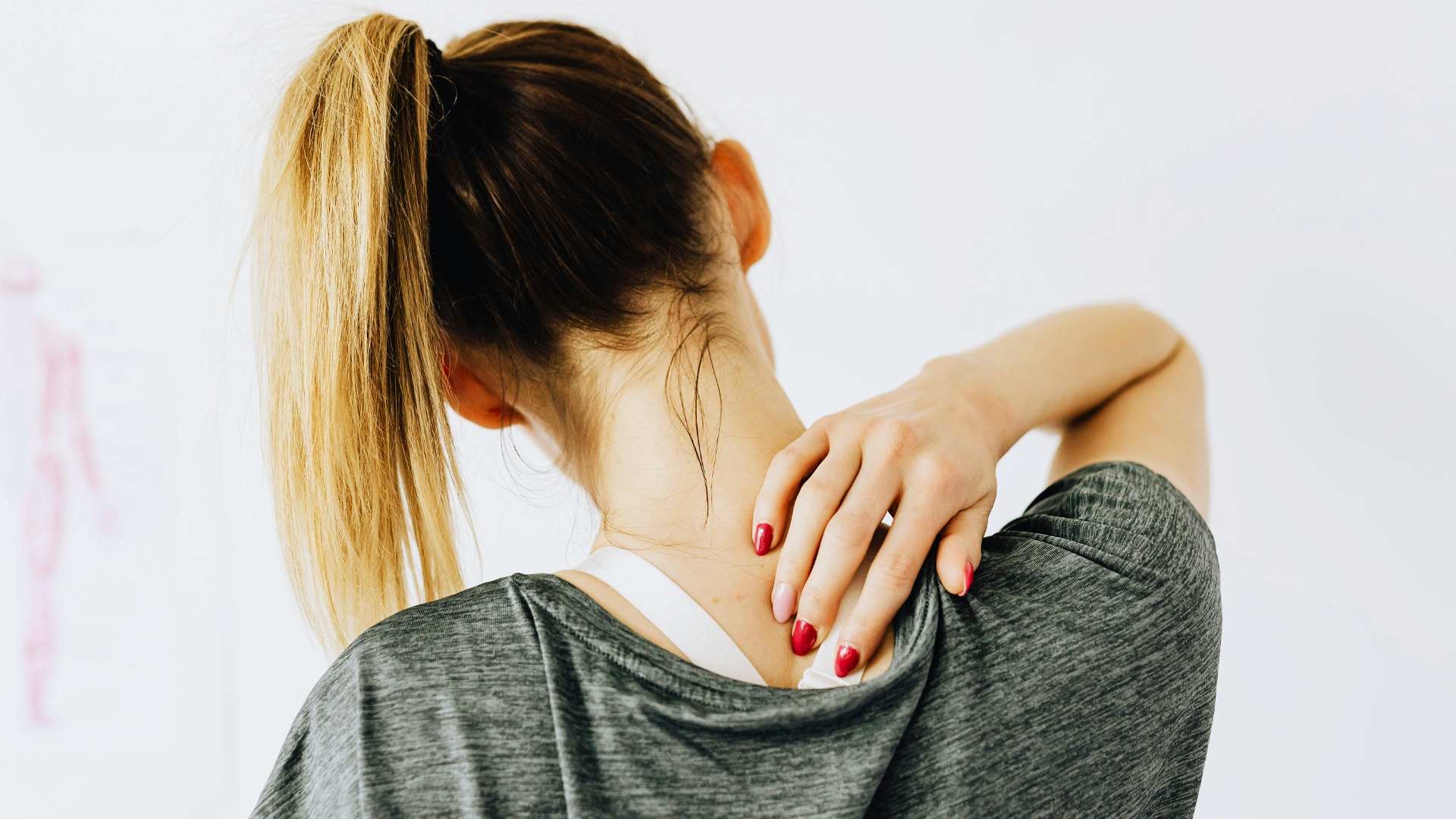 A girl from behind holding her neck