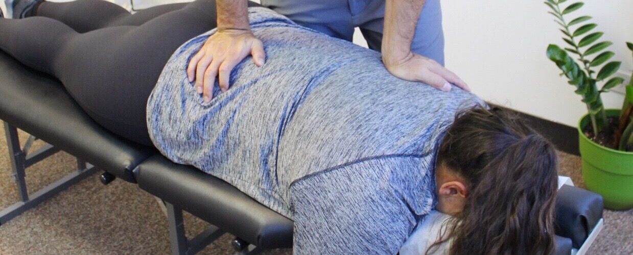 Dr. Shaun Ohira, working on patient's back.