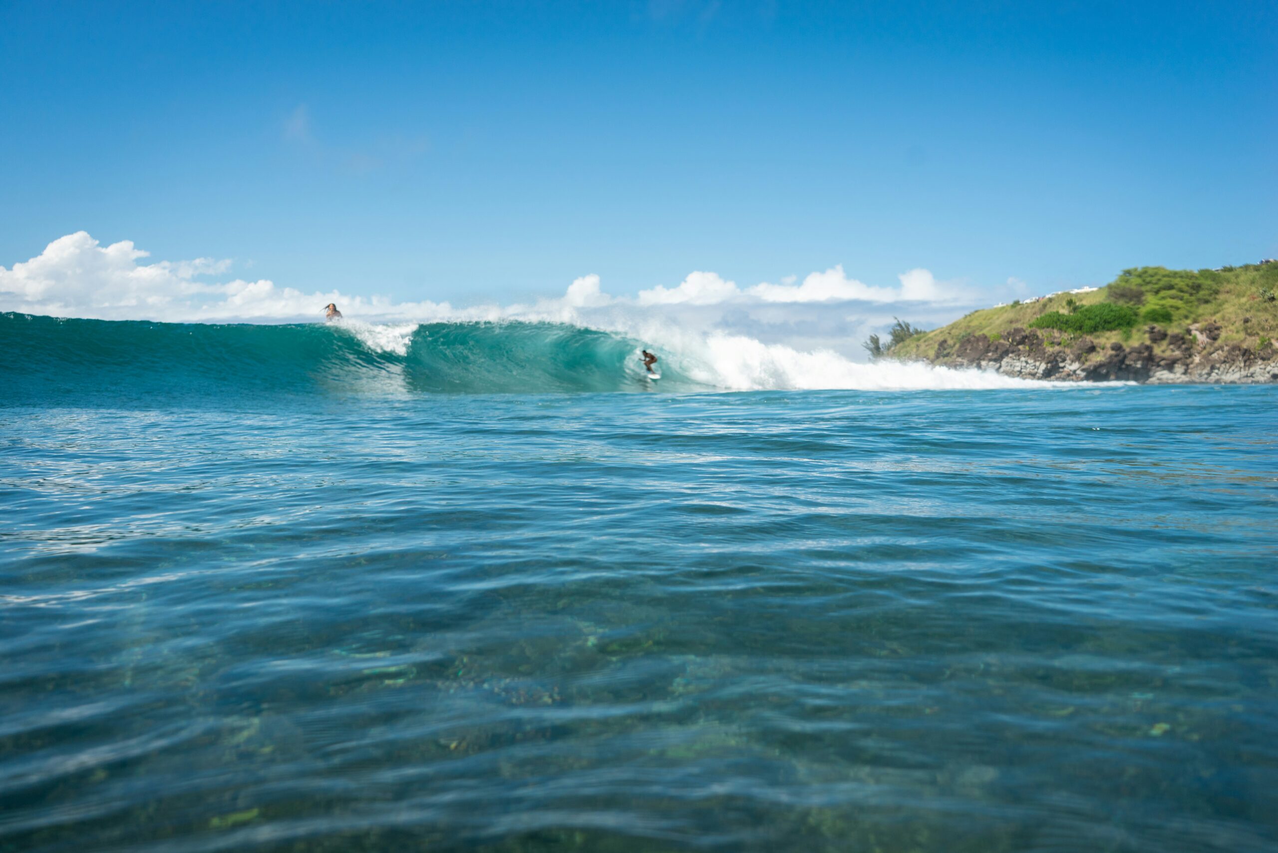 Surfer riding a breaking wave on a sunny day