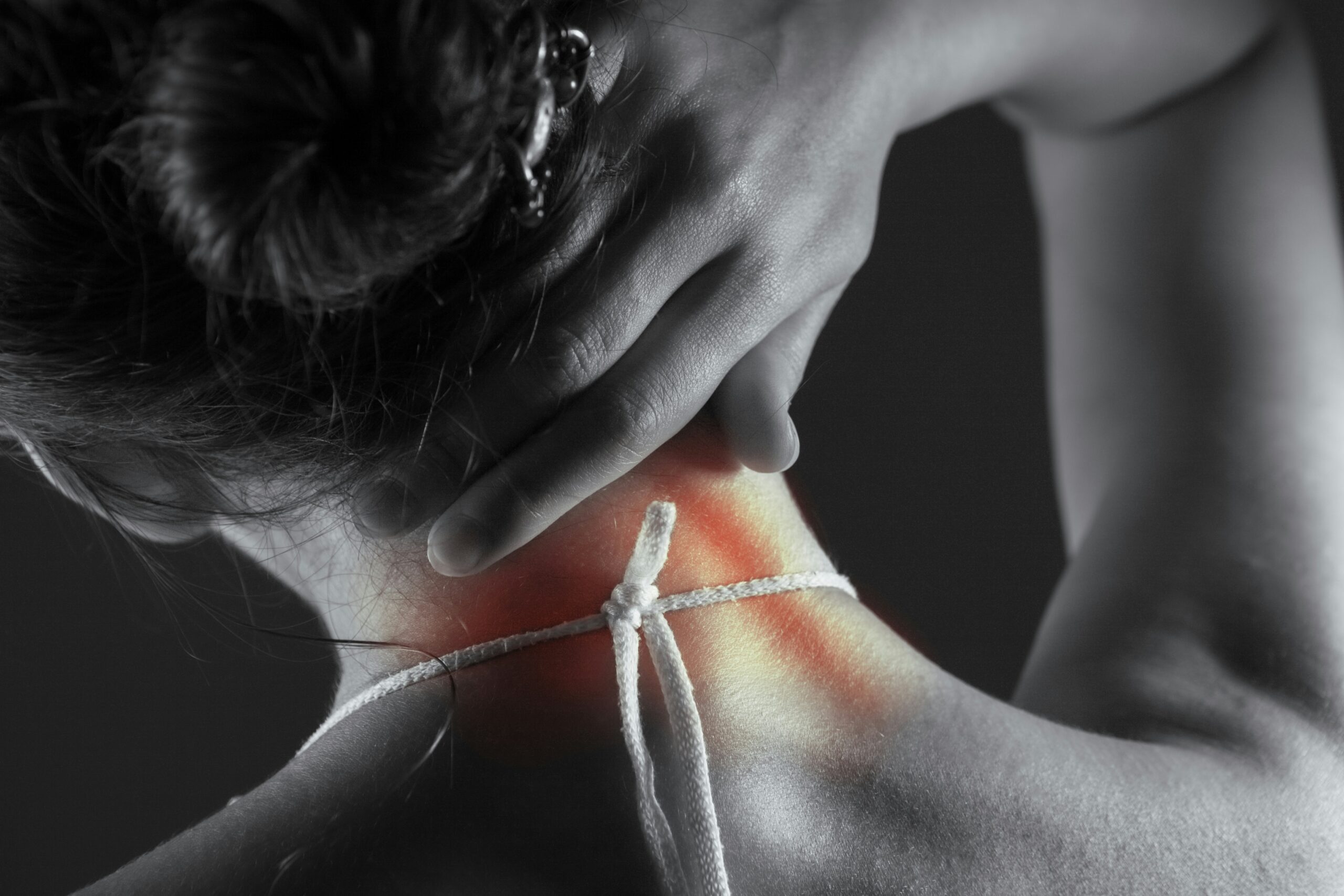 A lady holding her neck in pain