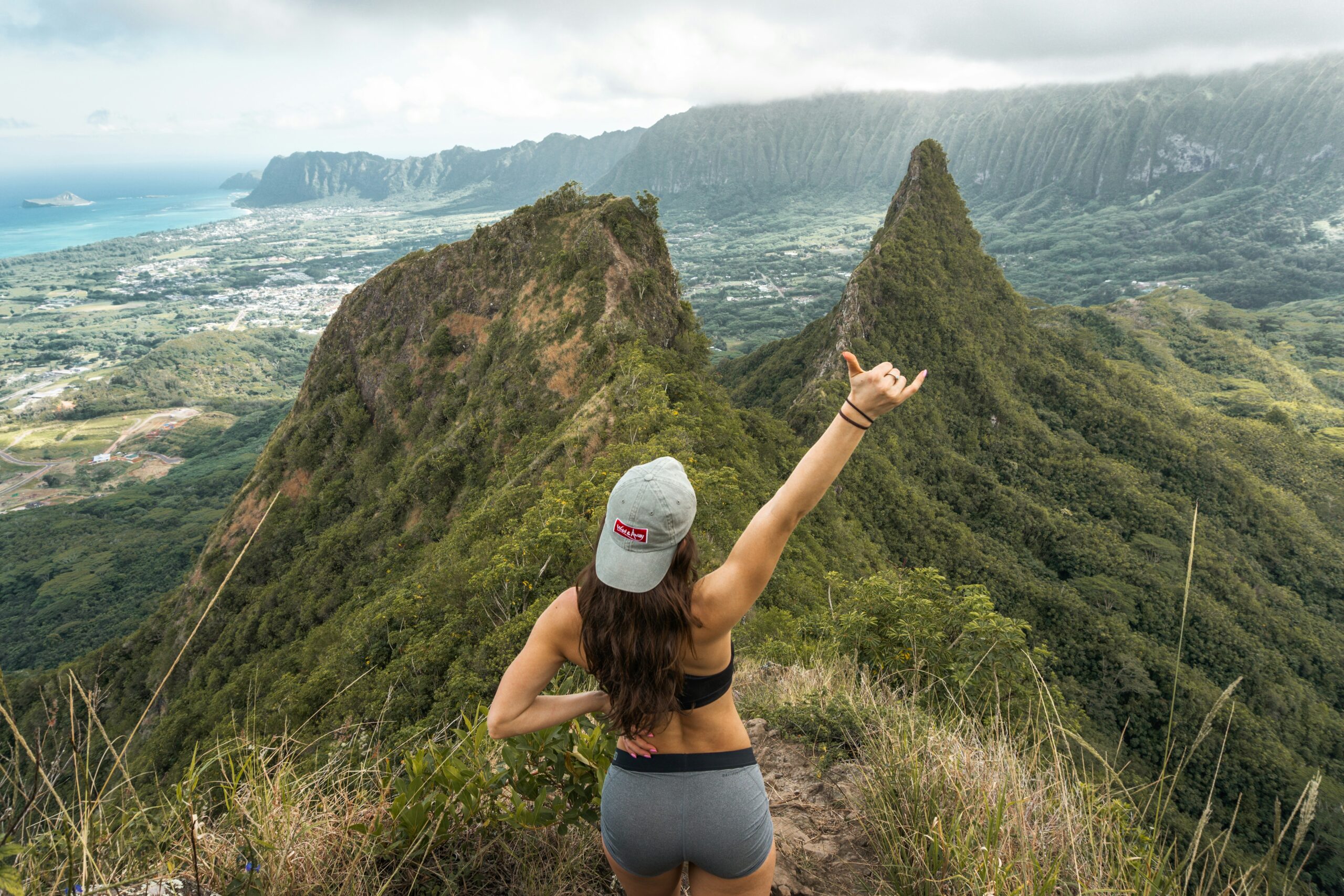 A hiking trail in Hawaii with a woman standing looking out
