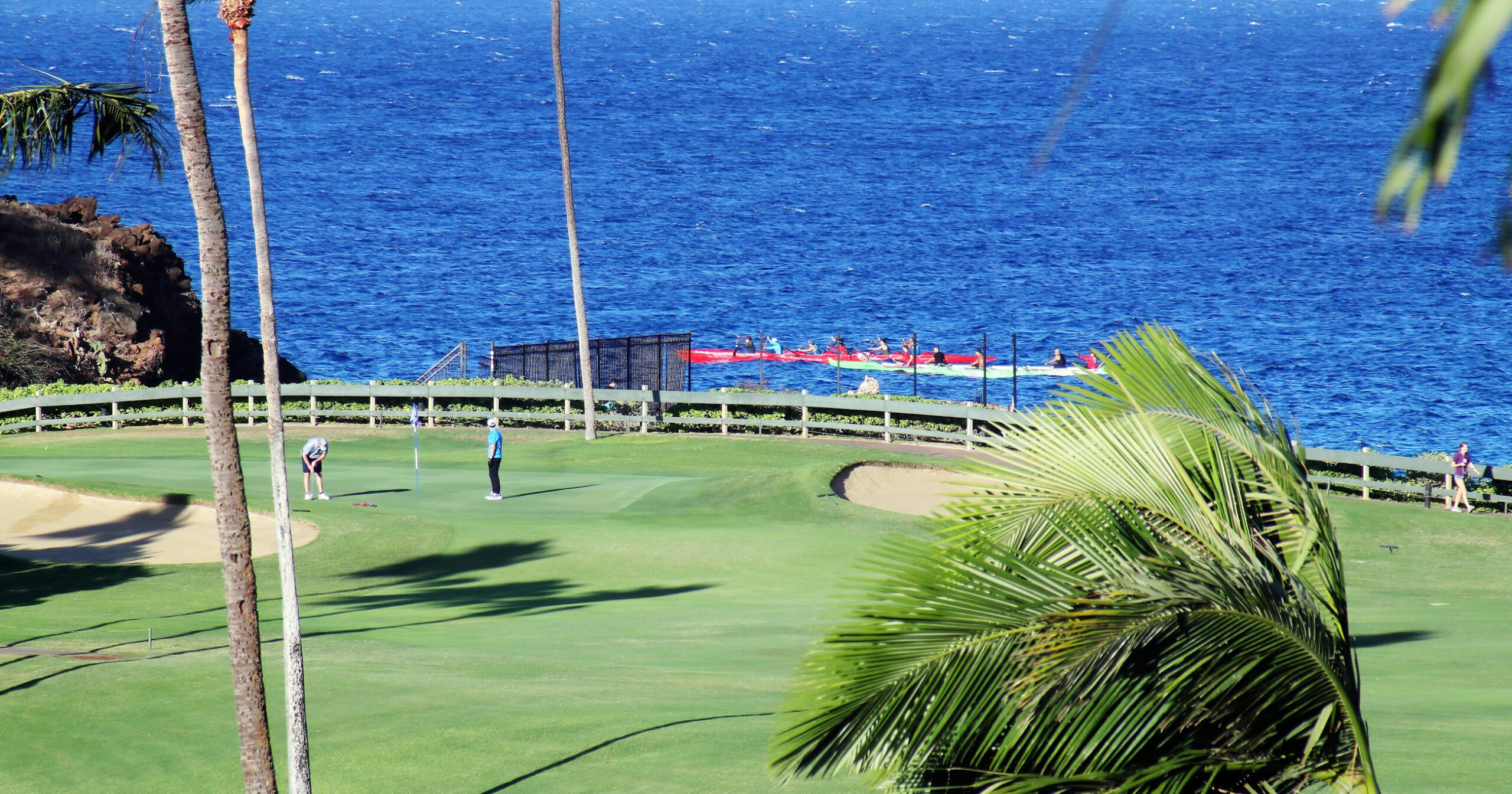 A putting green with beautiful ocean behind it