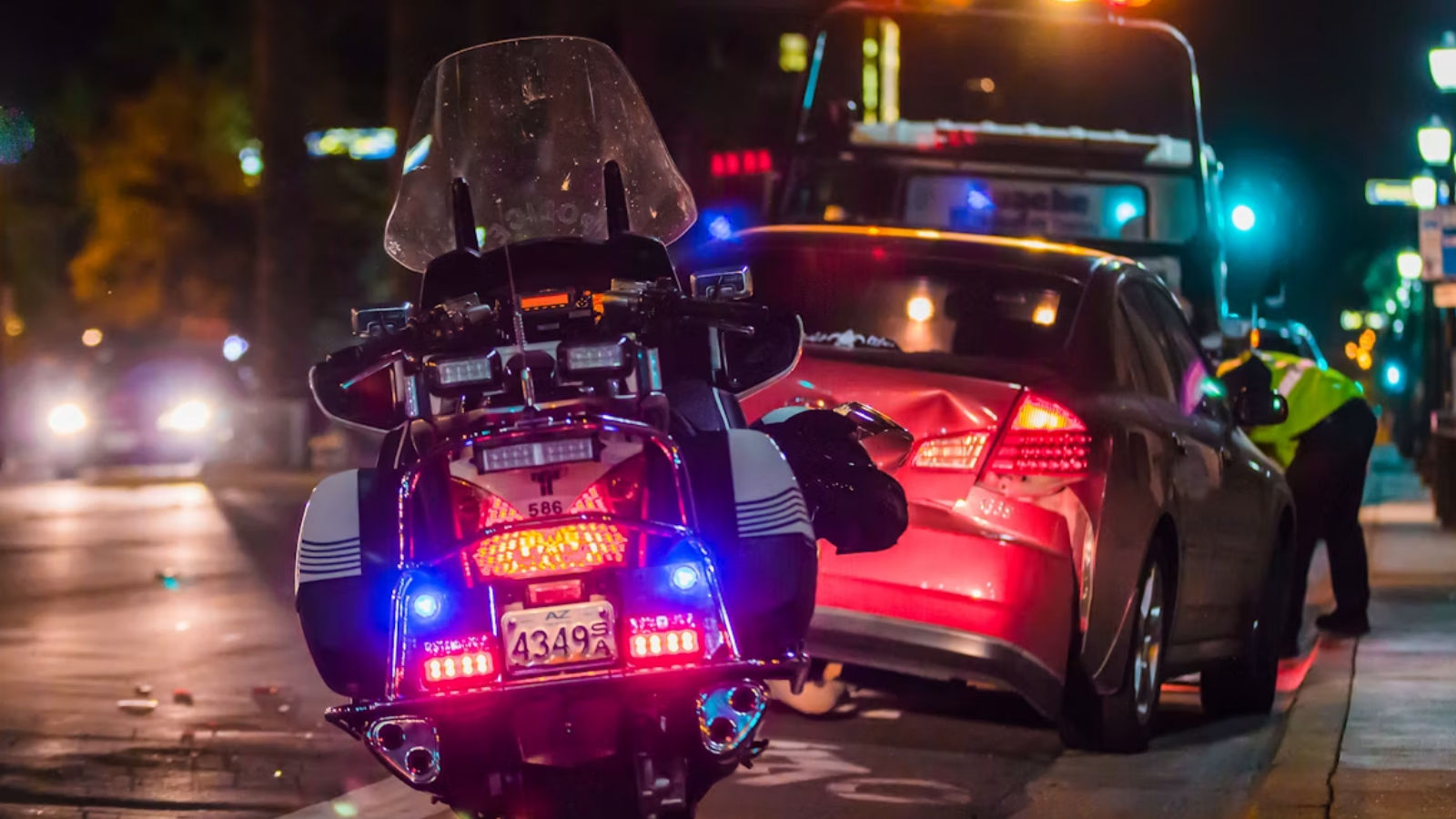 A police motorcycle pulled up behind a car accident at night
