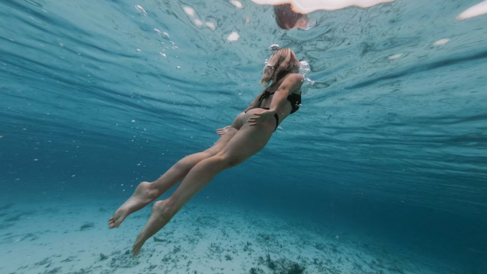 A woman swimming underwater in the ocean