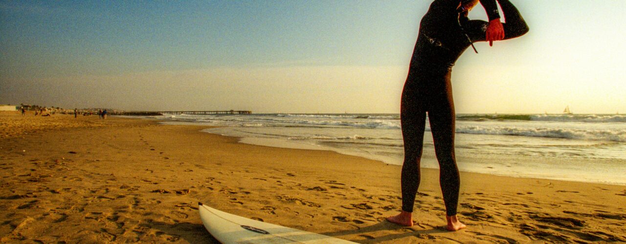 A surfer stretching on the beach