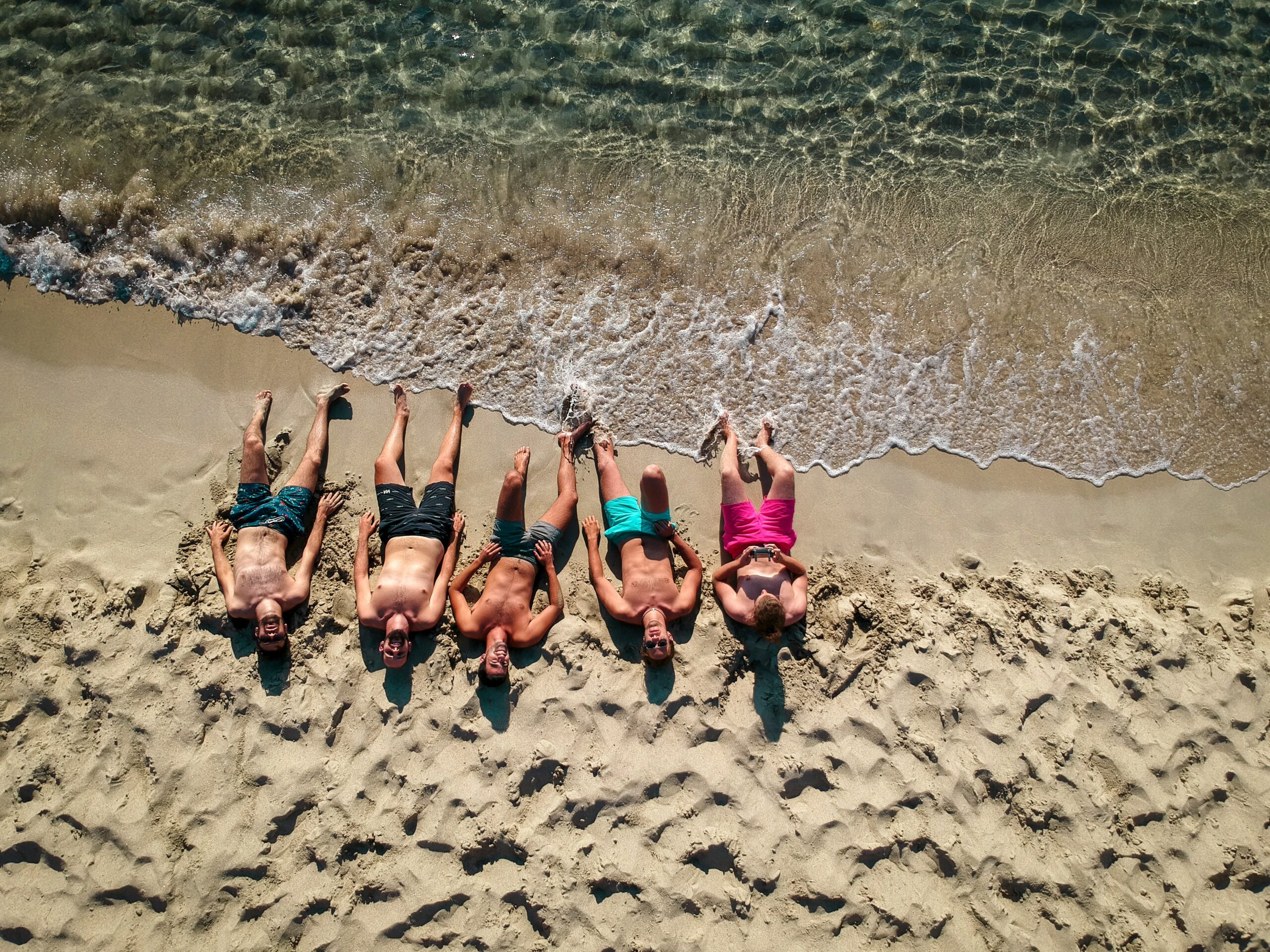 Five guys laying on the beach